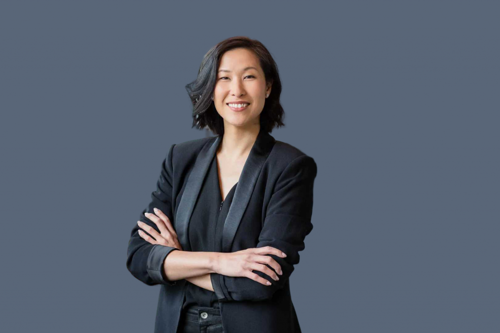 an asian woman professional headshot with dark grey background