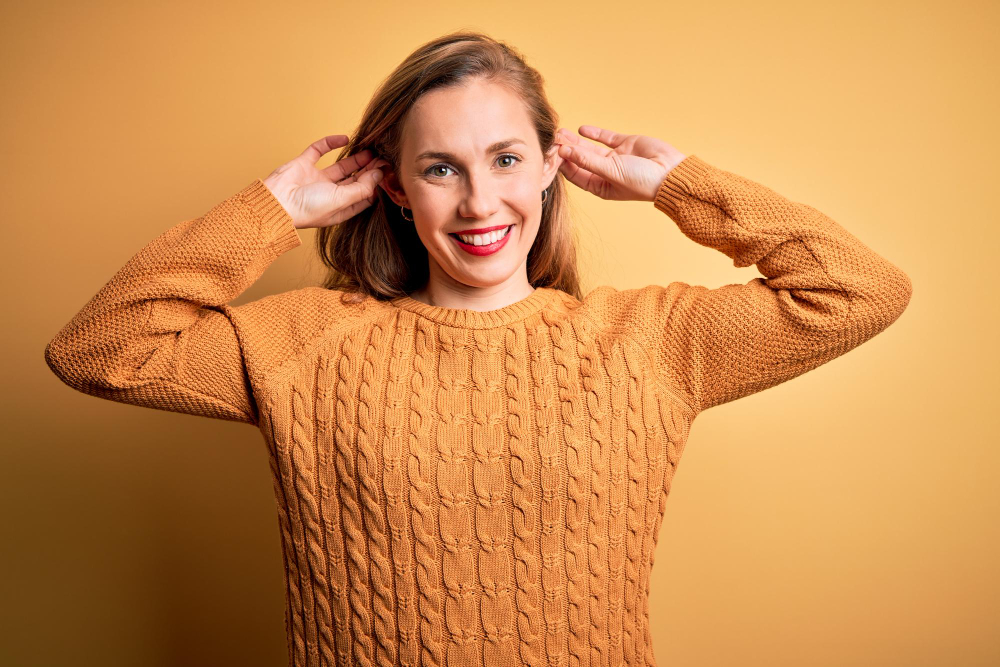 a woman is grabing her ears lightly