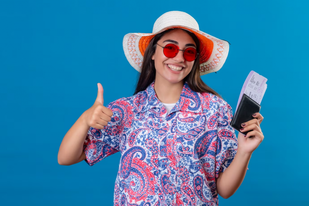 tourist woman with hat wearing red sunglasses holding passport and tickets smiling cheerfully