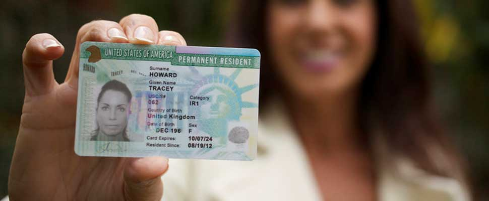 a woman holding her green card