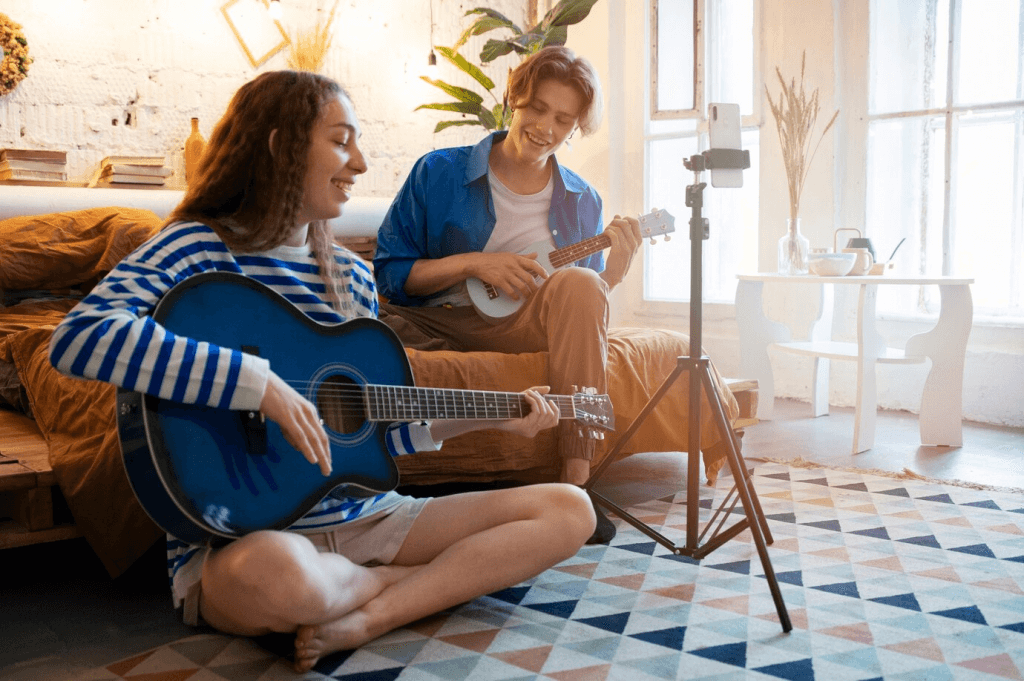 two young people playing guitar and singing