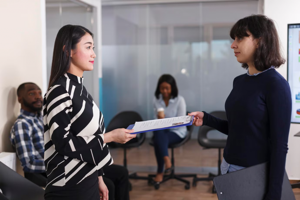 Mulher asiática desempregada entregando seu currículo ao gerente de recursos humanos para ser entrevistada